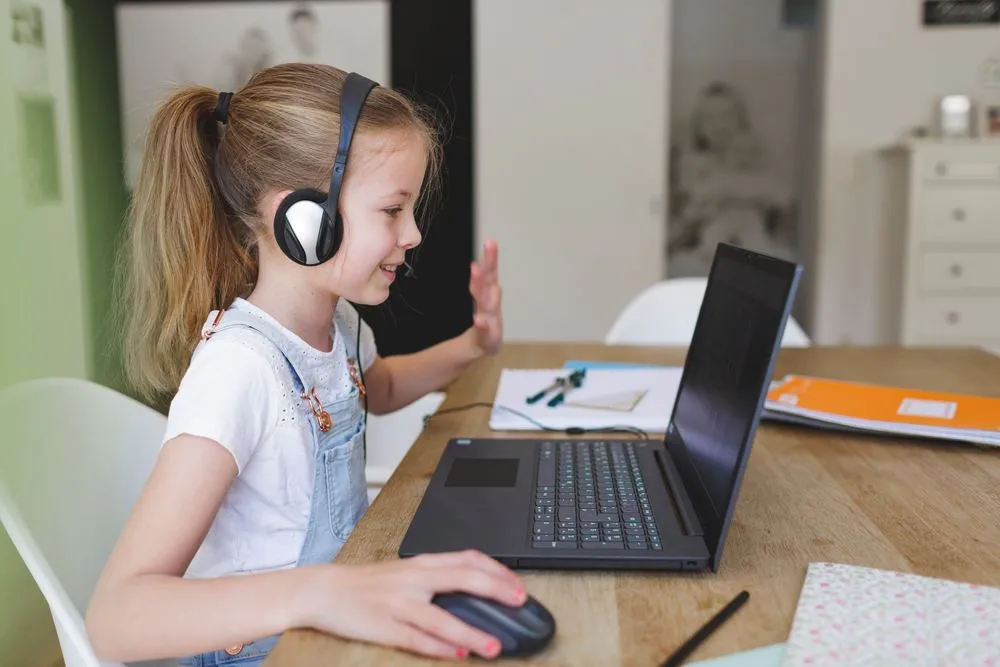 Un niño saludando a su profesor durante una clase online